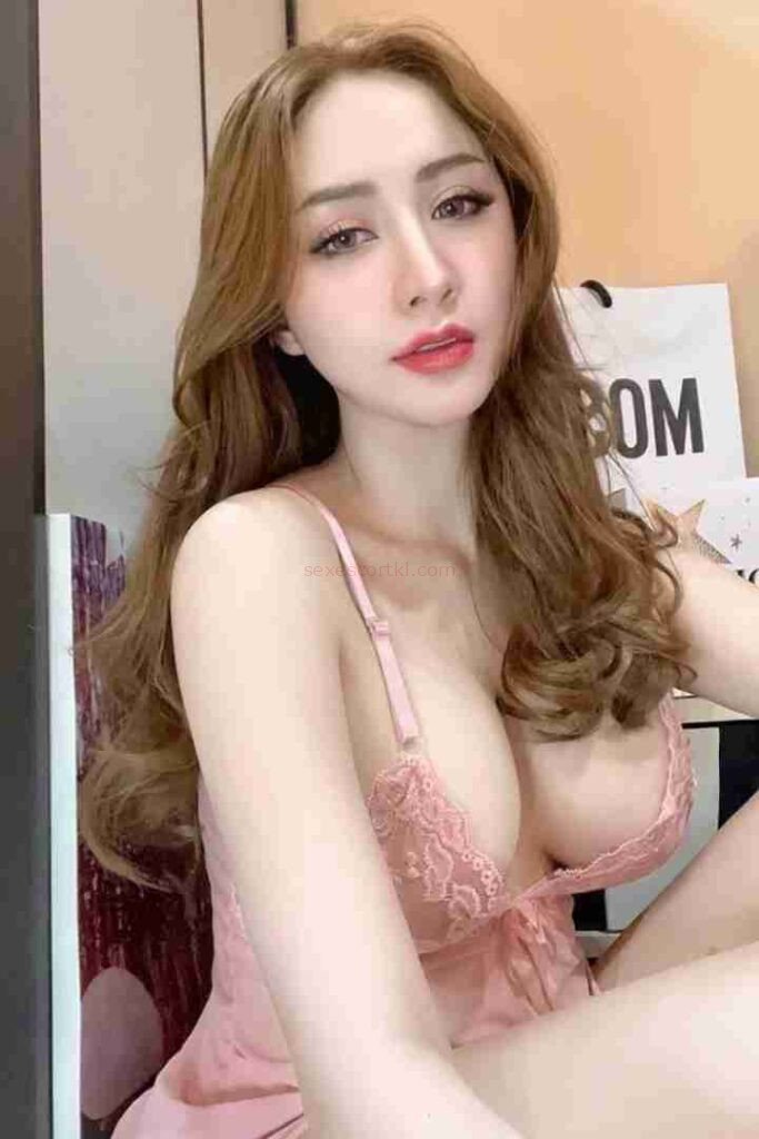 Attractive Asian woman in pink lingerie with long wavy hair. Nin Call Girl.