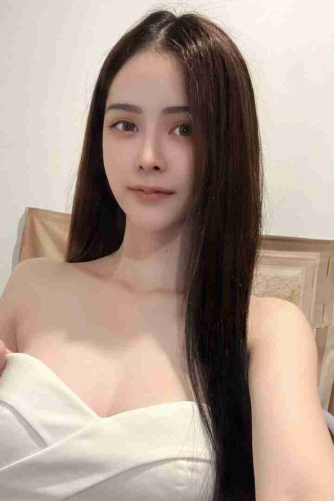 Attractive Asian woman with long dark hair and a strapless white top. Mild Escort Girl Malaysia.