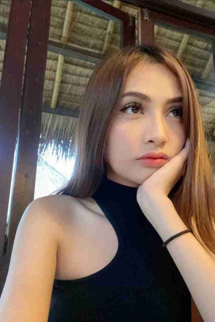 Attractive Malay woman with hand on face, wearing black top and bracelet. Zulla Malay Escort.