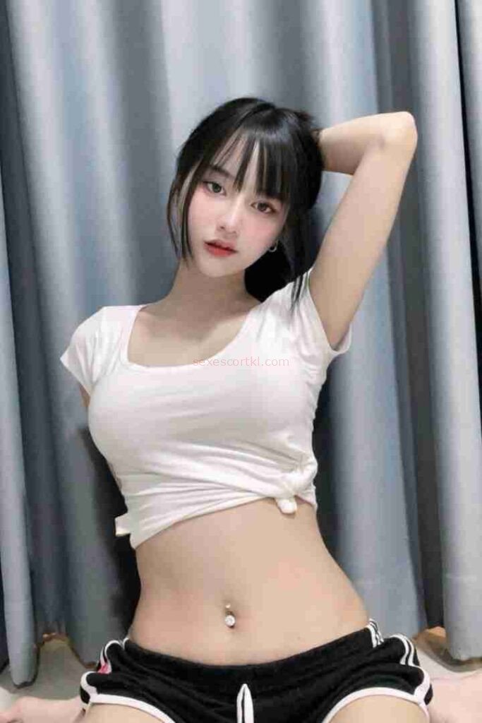 Attractive Asian woman in white top and black shorts posing. Kannika Thai Escort.