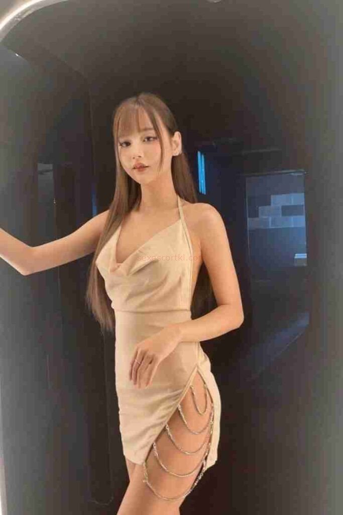 Kannika Thai escort in beige dress with chain detail.