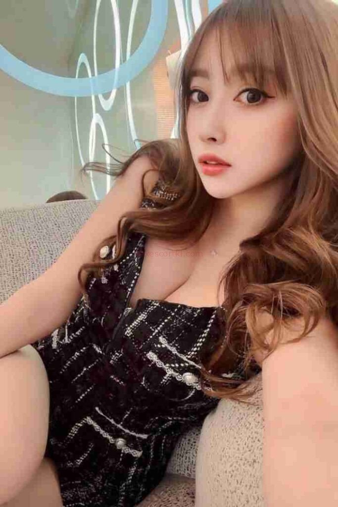 Attractive Asian woman with brown hair in black dress. Li Jing Chinese Escort.