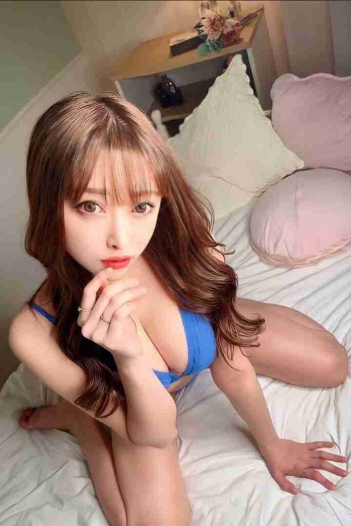 Beautiful Asian woman, Li Jing, in blue lingerie on bed. Chinese Escort.