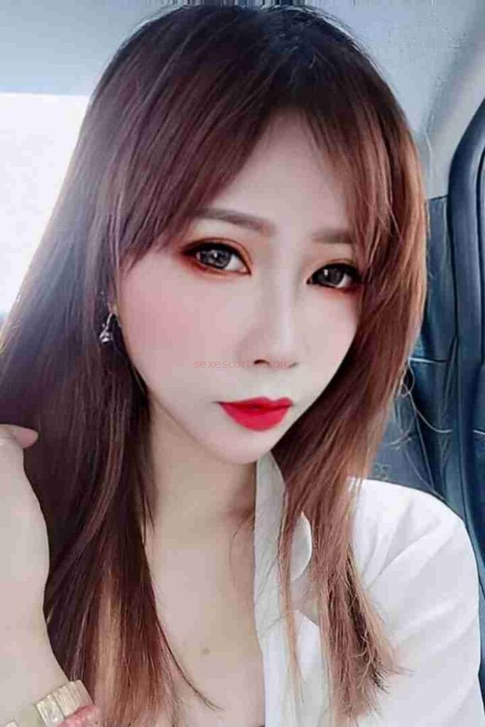 Close-up of Lienna with red lipstick and auburn hair. Escort Girl Services.