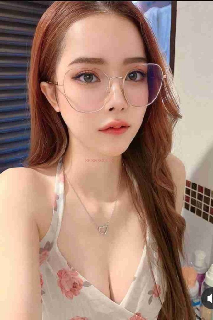 Attractive woman with glasses and a floral top, looking at the camera.