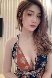 Beautiful Asian woman with long wavy hair wearing a patterned halter top. Portrait shot.