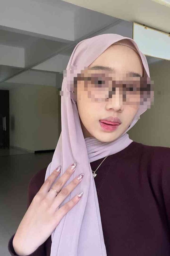 Sex Escort KL Girl Kesya, a Malay call girl in Kuala Lumpur, wearing a pink hijab and glasses Incall & Outcall Escorts Girl Service